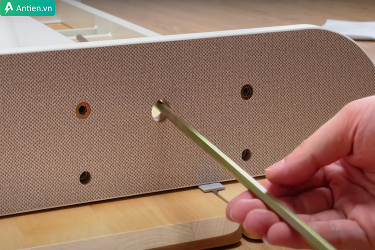 Luồn trục xoay nâng hạ độ cao bàn trước khi lắp chân bàn bên trái